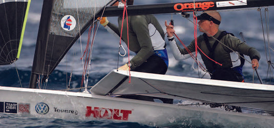 Deux hommes naviguant sur un voilier léger, illustrant l'équipement spécialisé pour dériveurs et catamarans sportifs proposé par Yachting Thommeret.