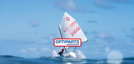 Un homme en chapeau rouge navigue un dériveur avec une voile blanche marquée de texte rouge sur l'eau, illustrant les équipements de voile légère.
