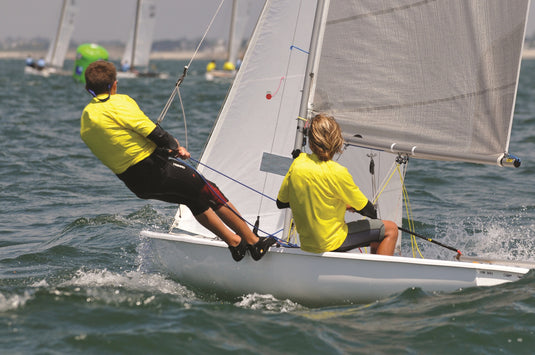 Deux jeunes naviguent sur un dériveur, l'un au rappel, l'autre à la barre, sur le plan d'eau de La Rochelle