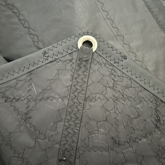 Spi Catamaran KL / SL 15.5 avec tissu Nylite 1.1Oz, présentant des coutures renforcées en zig-zag et un œillet métallique pour fixation.