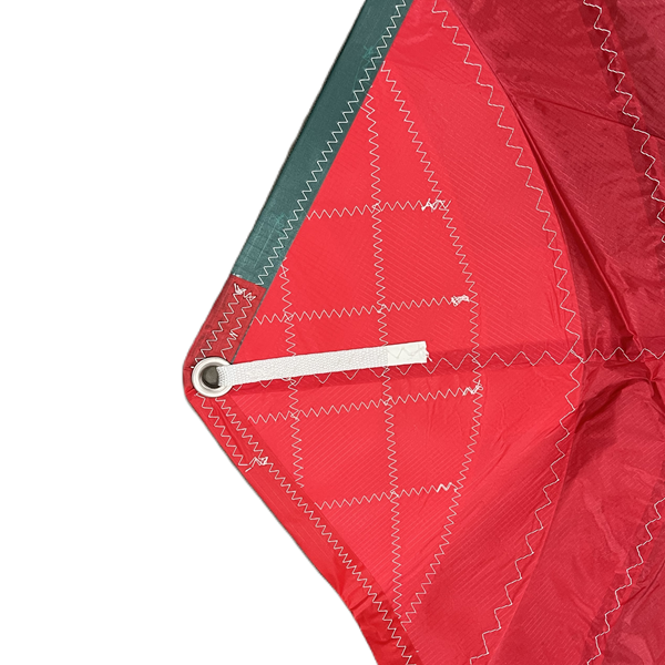 Laden Sie das Bild in Galerie -Viewer, Gros plan sur le coin renforcé du Spi Dériveur 420 Standard, montrant une couture en zigzag robuste, une patte cousue et un œillet métallique pour attache.
