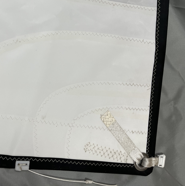 Chargez l'image dans la visionneuse de la galerie, Détail du point d'écoute avec un nerf de chute, coulisseau en l'absence de ralingue de bôme, et sangles cousues sur l’œillet pour renforcer.
