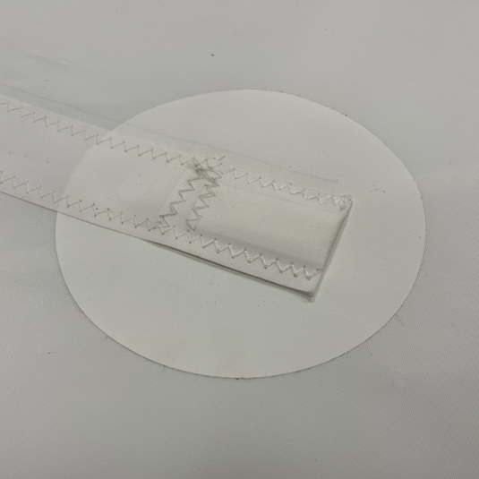 Grand Voile Dériveur 420, détail d'un renfort circulaire en Dacron blanc avec sangle renforcée, idéal pour la voile légère et sportive.