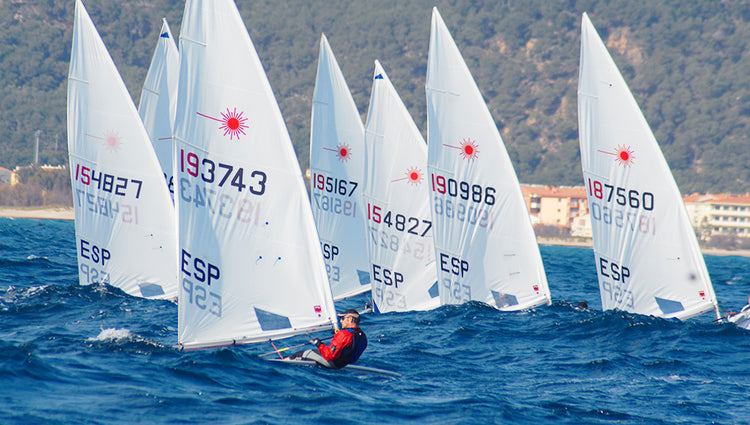 7 laser naviguent au pres en regate vers la bouee sous le soleil et sur la mer bleue